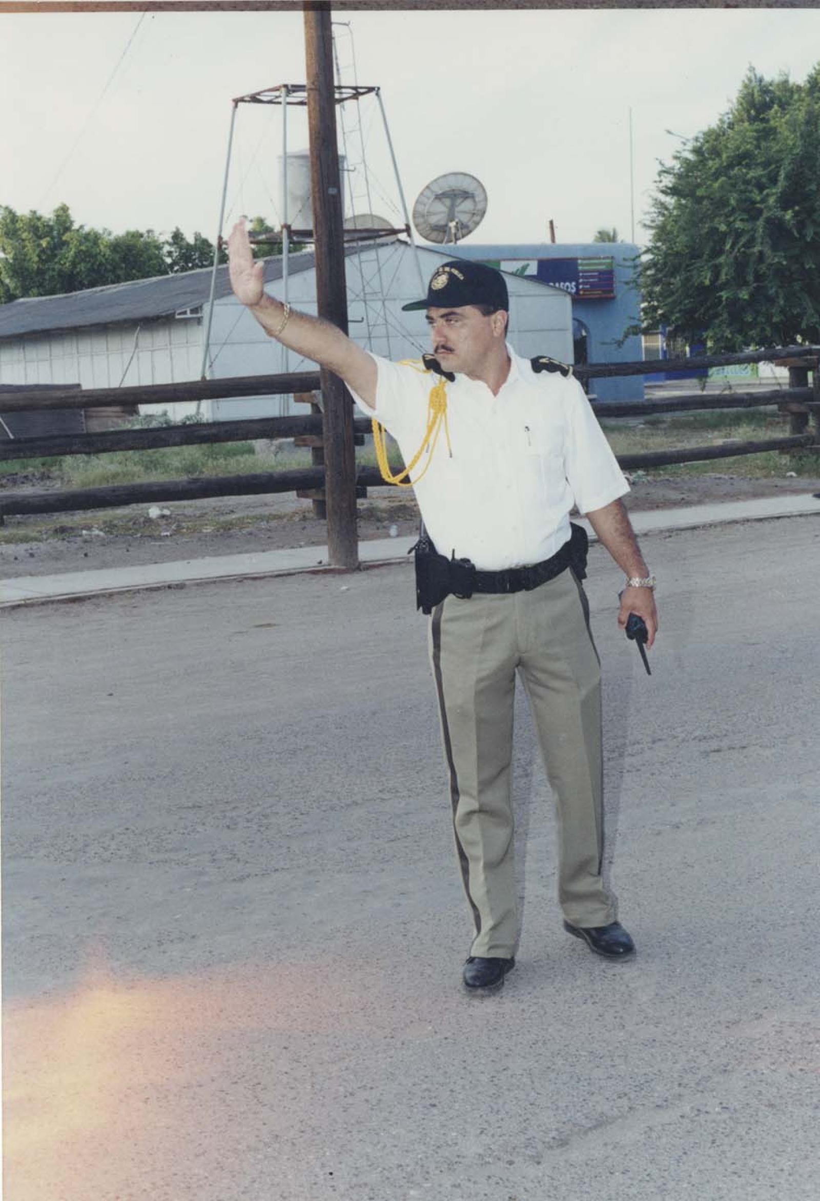 Agente de tránsito da señal de alto.