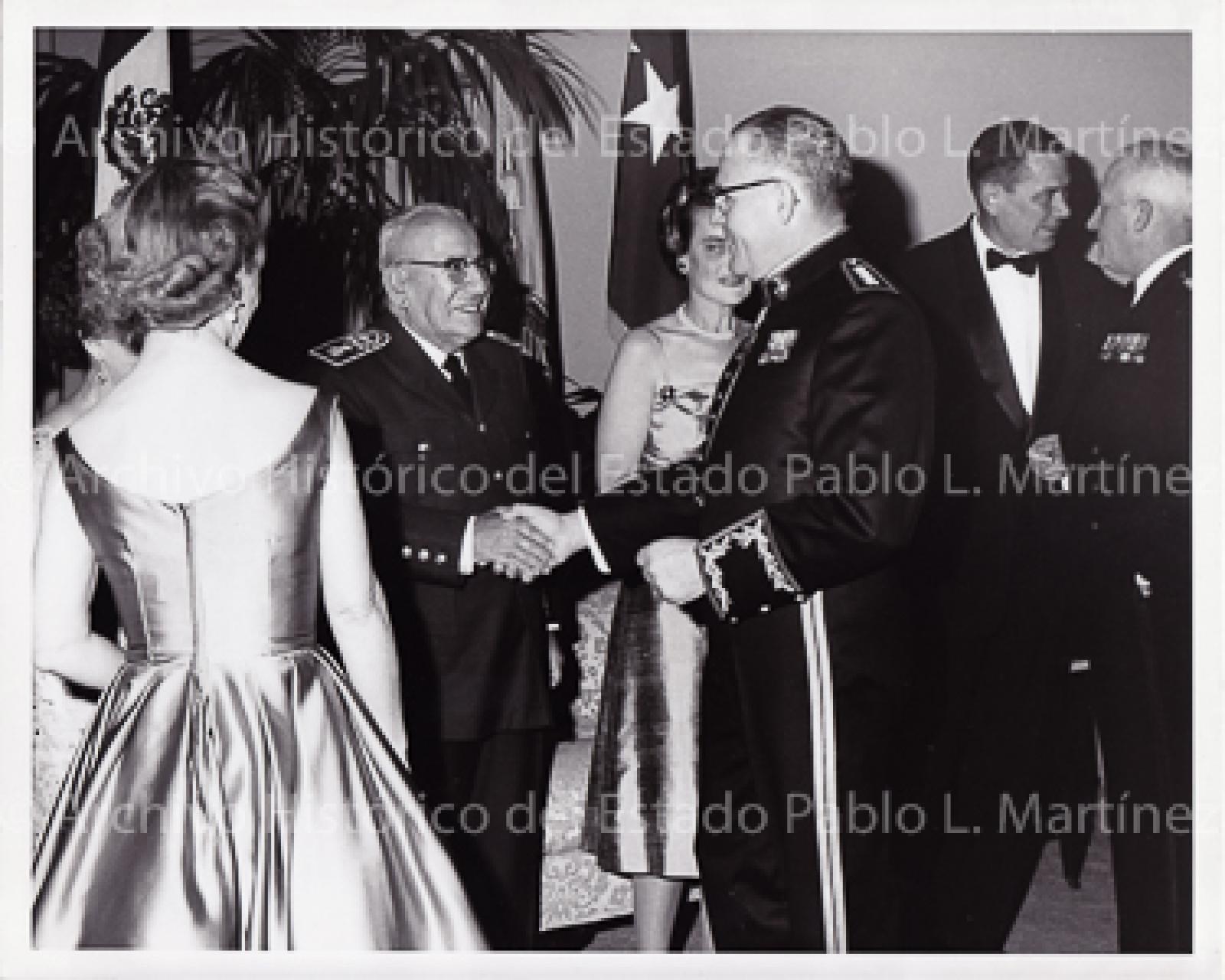 Agustín Olachea saluda a militar en evento.