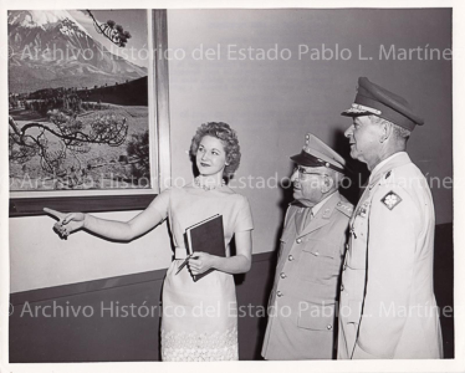Agustín Olachea y Edward Thomas observan pintura de volcán mexicano.