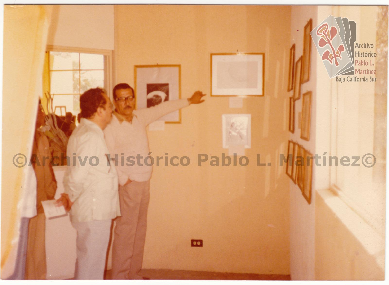 Ángel César Mendoza Arámburo y Néstor Agúndez Martínez observan exposición de pinturas y dibujos, en el Centro Cultural de Todos Santos, Baja California Sur.