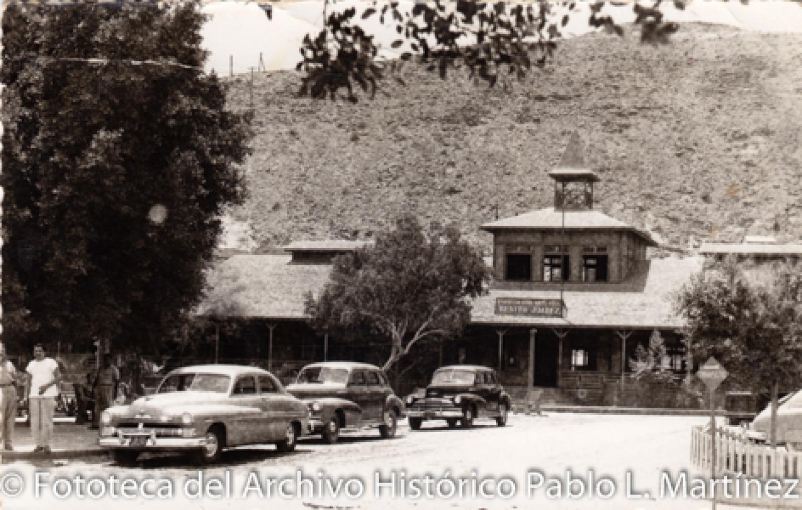 Automóviles frente a escuela Benito Juárez en Santa Rosalía, Baja California.