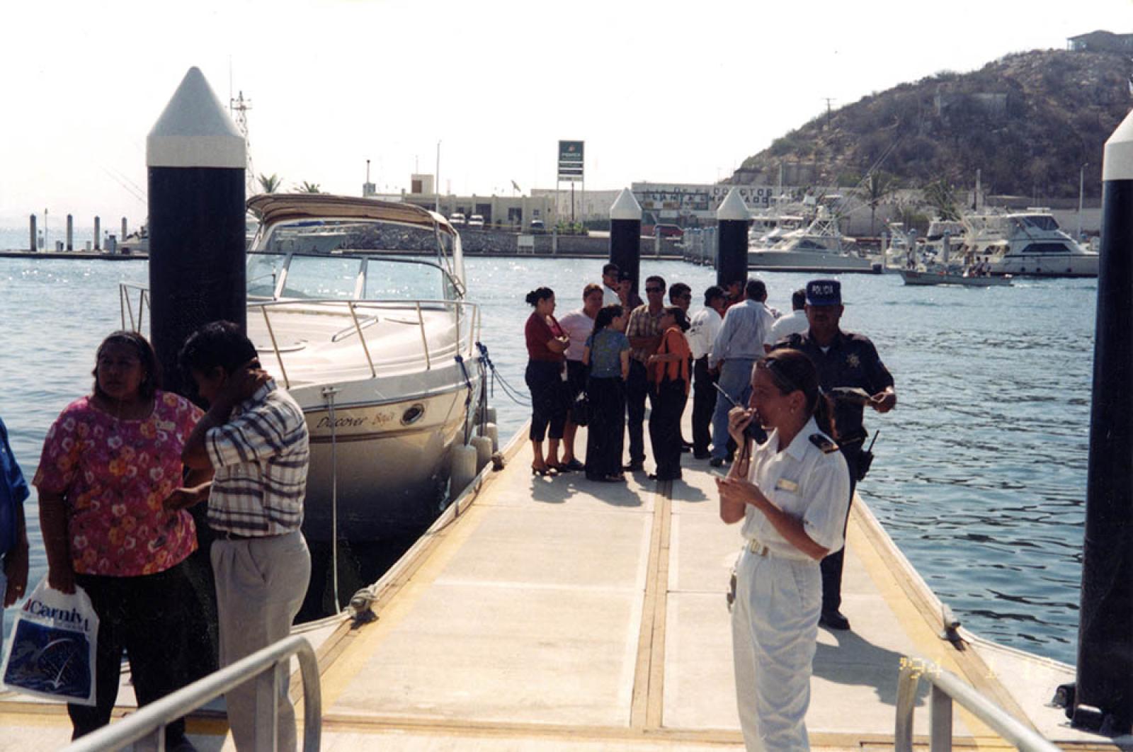 “Autoridades judiciales, de marinas y de salud reunidas en muelle”.