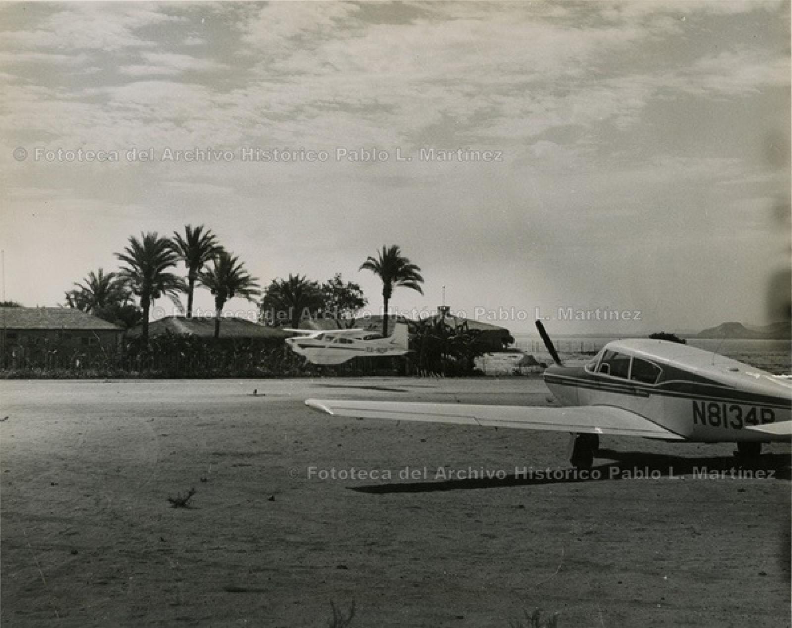 Avionetas y chozas, en playa.
