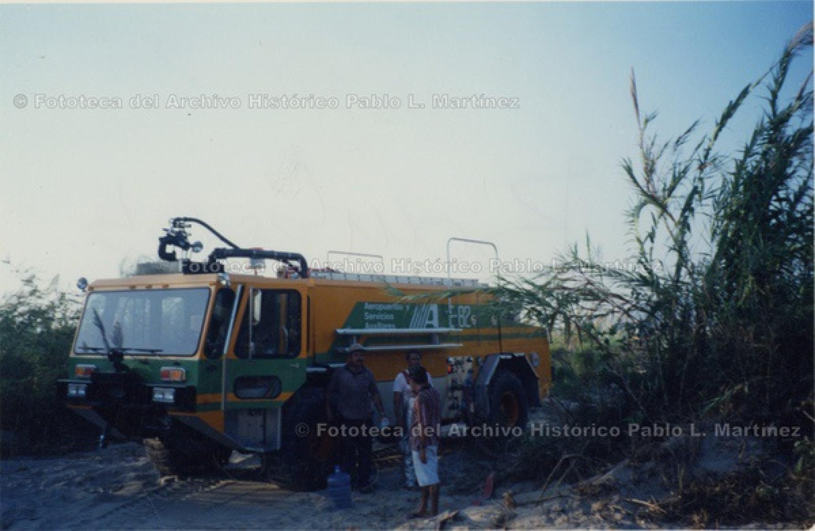 “Bomberos y camión de Aeropuertos y Servicios Auxiliares” en terreno baldío.