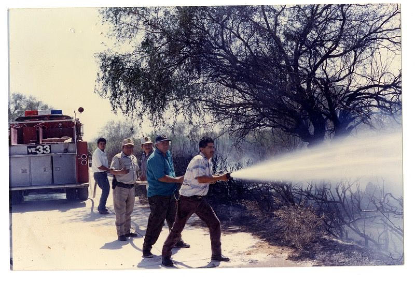 Bomberos y policías sofocando incendio.