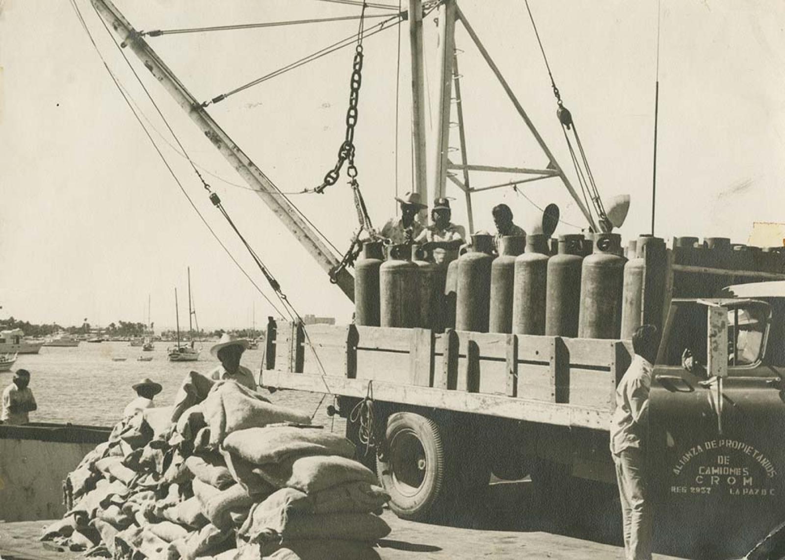 Camión cargado de tanques de gas sobre muelle.