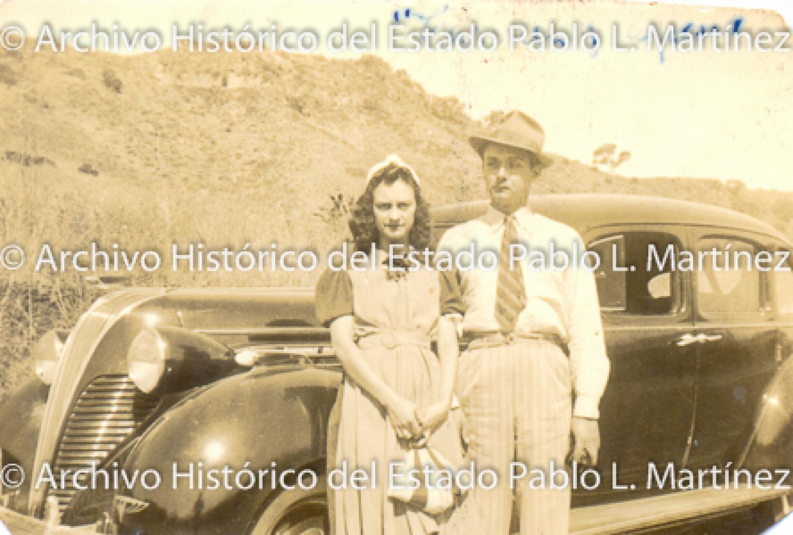 Carmen y esposo, frente a carro.