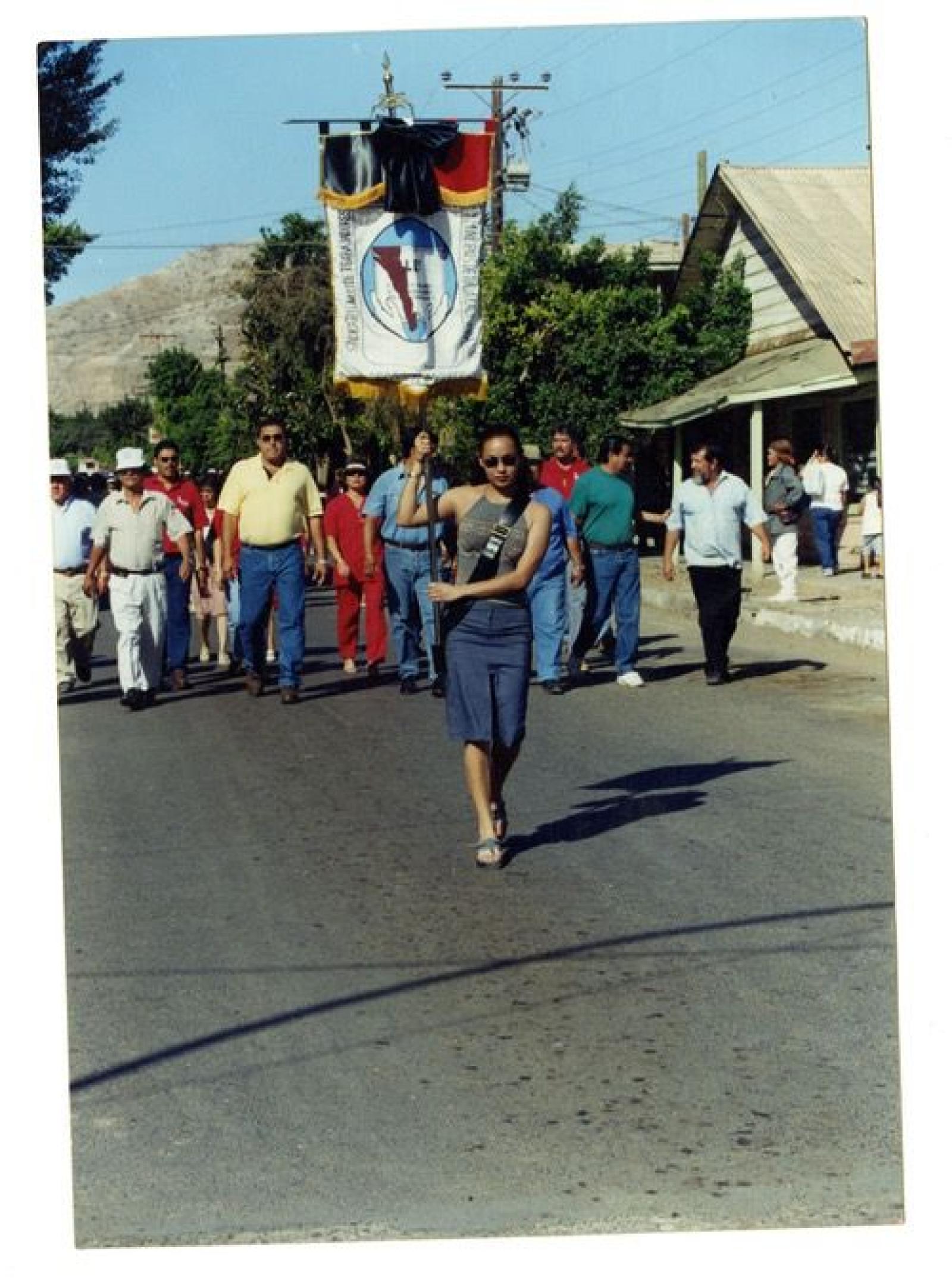 “Claudia Melina Cazares Castro, porta el estandarte del Sindicato de Burócratas en el desfile del Primero de Mayo.”