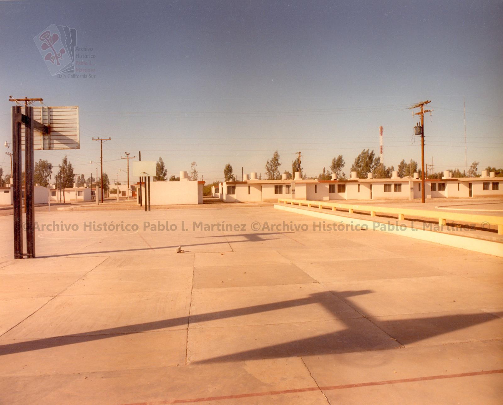 Conjunto habitacional recién construido, visto desde unas canchas deportivas.