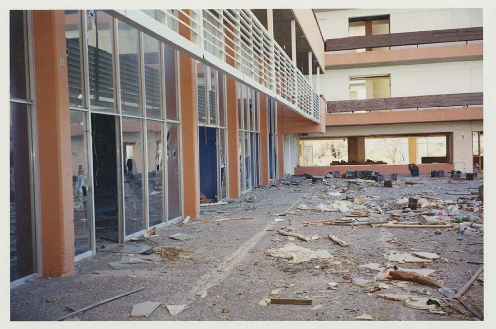 Edificio con vidrios rotos y “suciedad” en su interior y patio.
