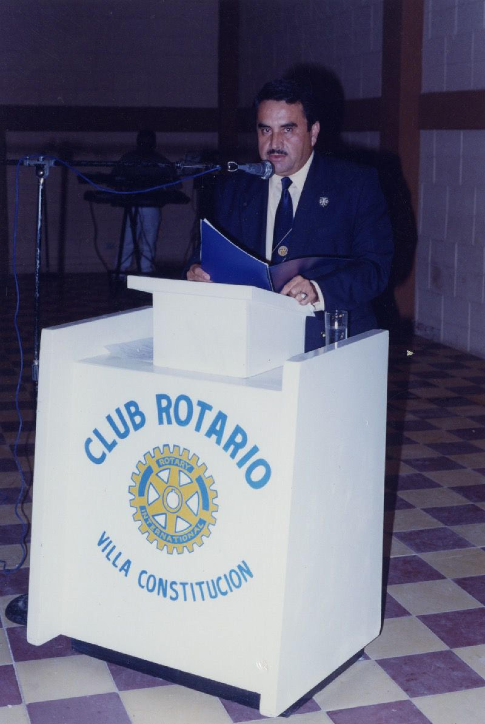 “El doctor Humberto da discurso desde estrado del Club Rotario de Villa Constitución”.