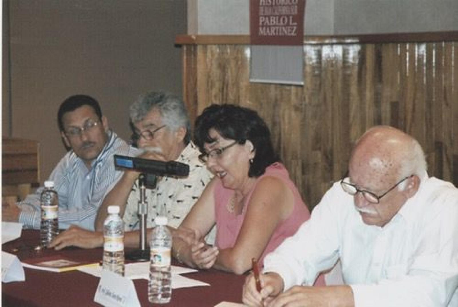 Elizabeth Acosta comenta su obra Paisajes y personajes en María Auxiliadora, Baja California Sur, desde mesa de ponentes.