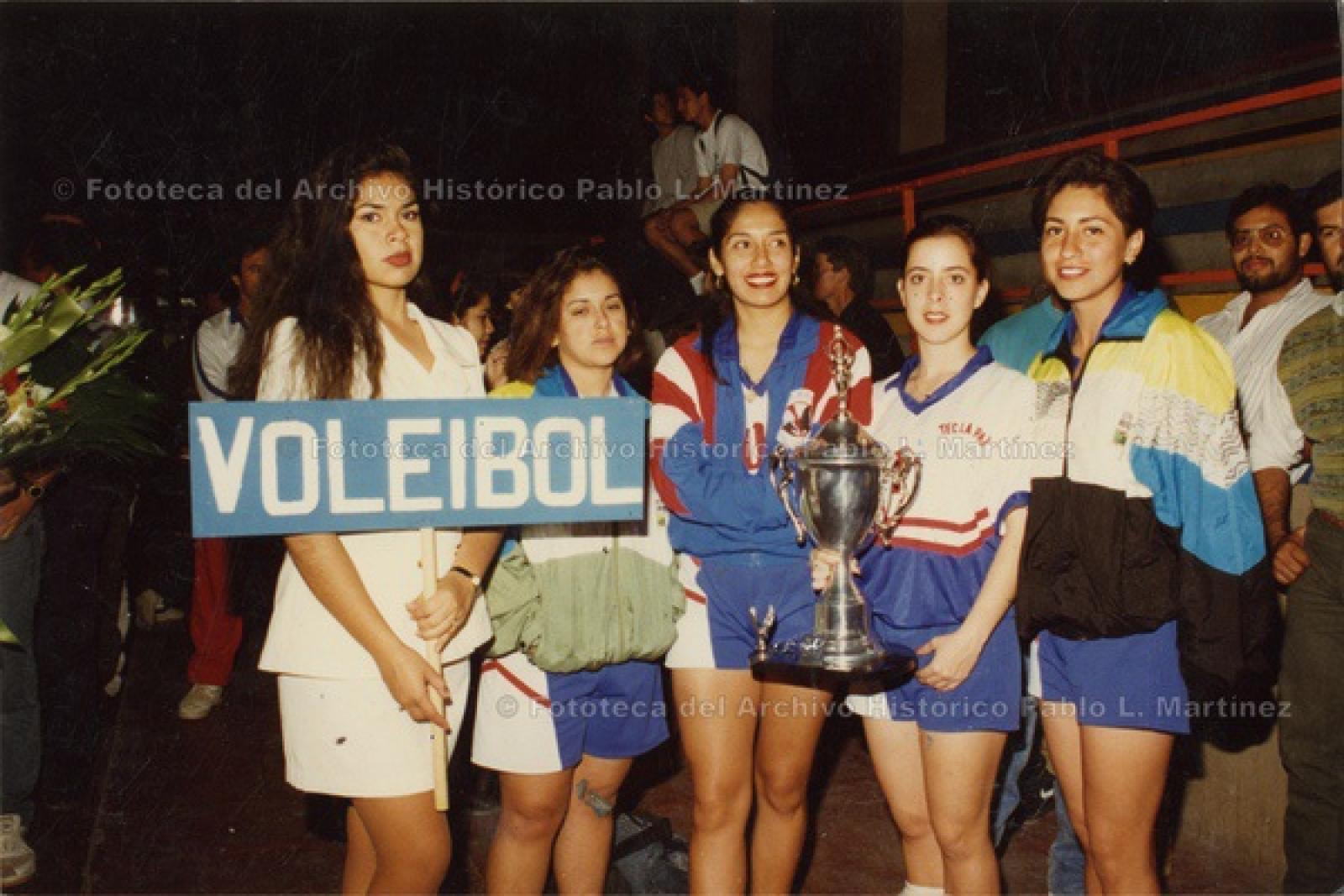 Equipo femenil de vóleibol, con trofeo.