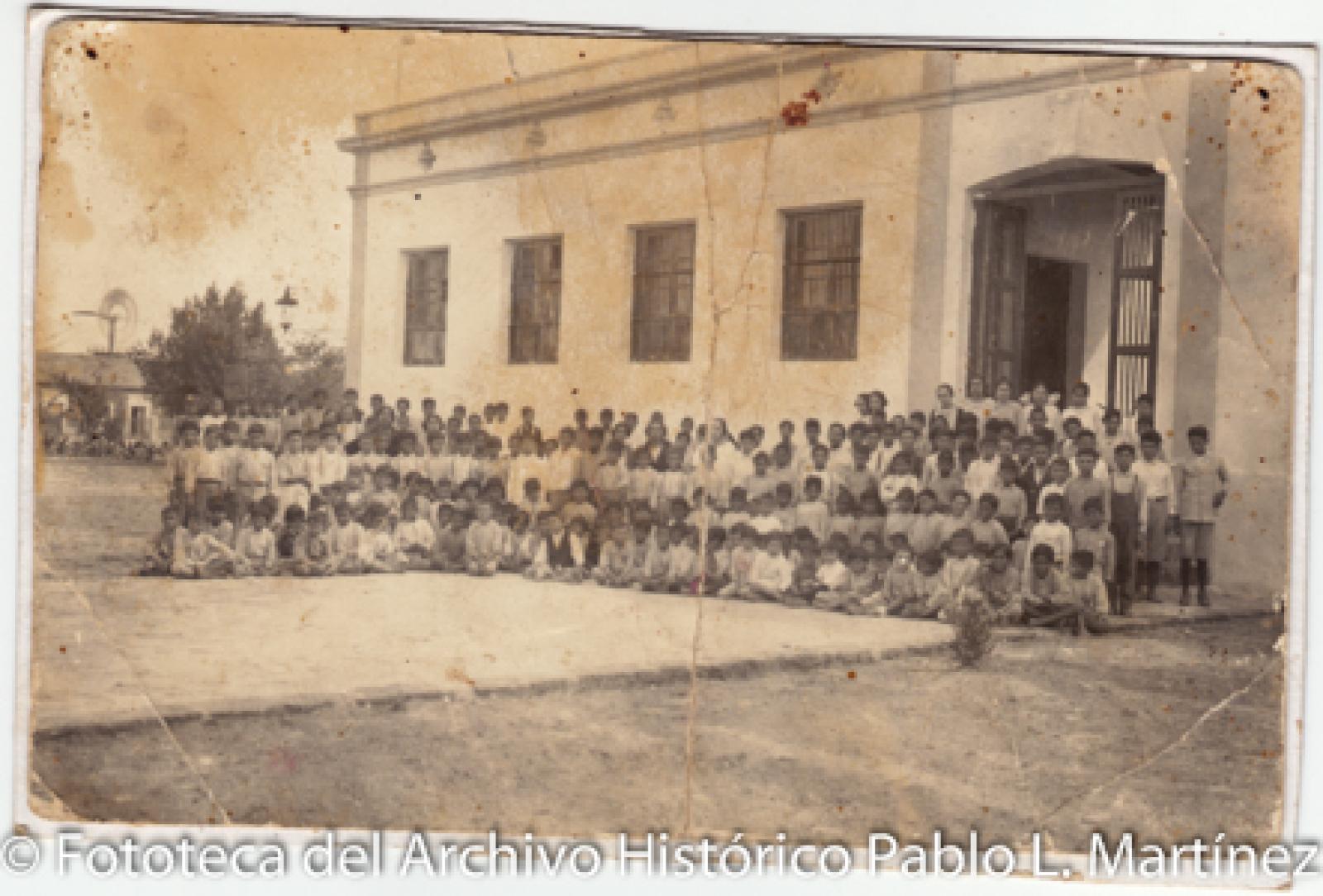 “Escuela Miguel Hidalgo y Costilla. Grupo de alumnos en la entrada principal.”