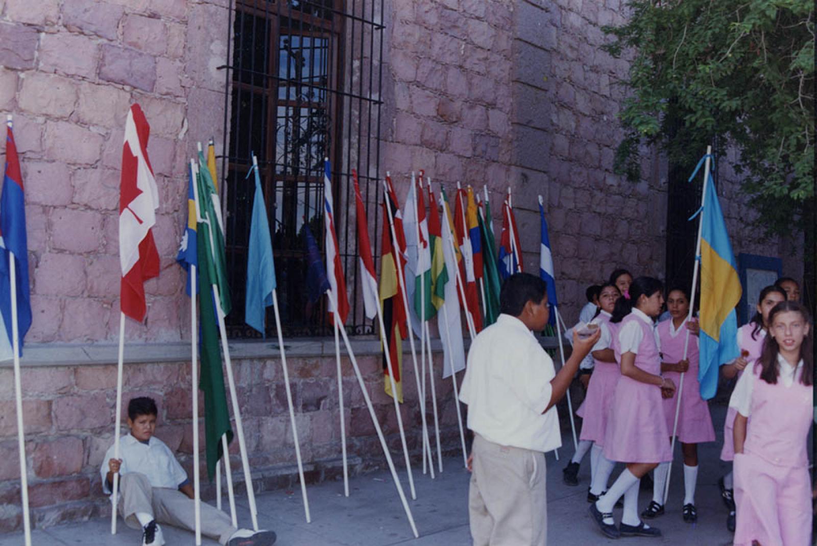 Estudiantes de secundaria con banderas de países en el exterior de la Biblioteca Justo Sierra.
