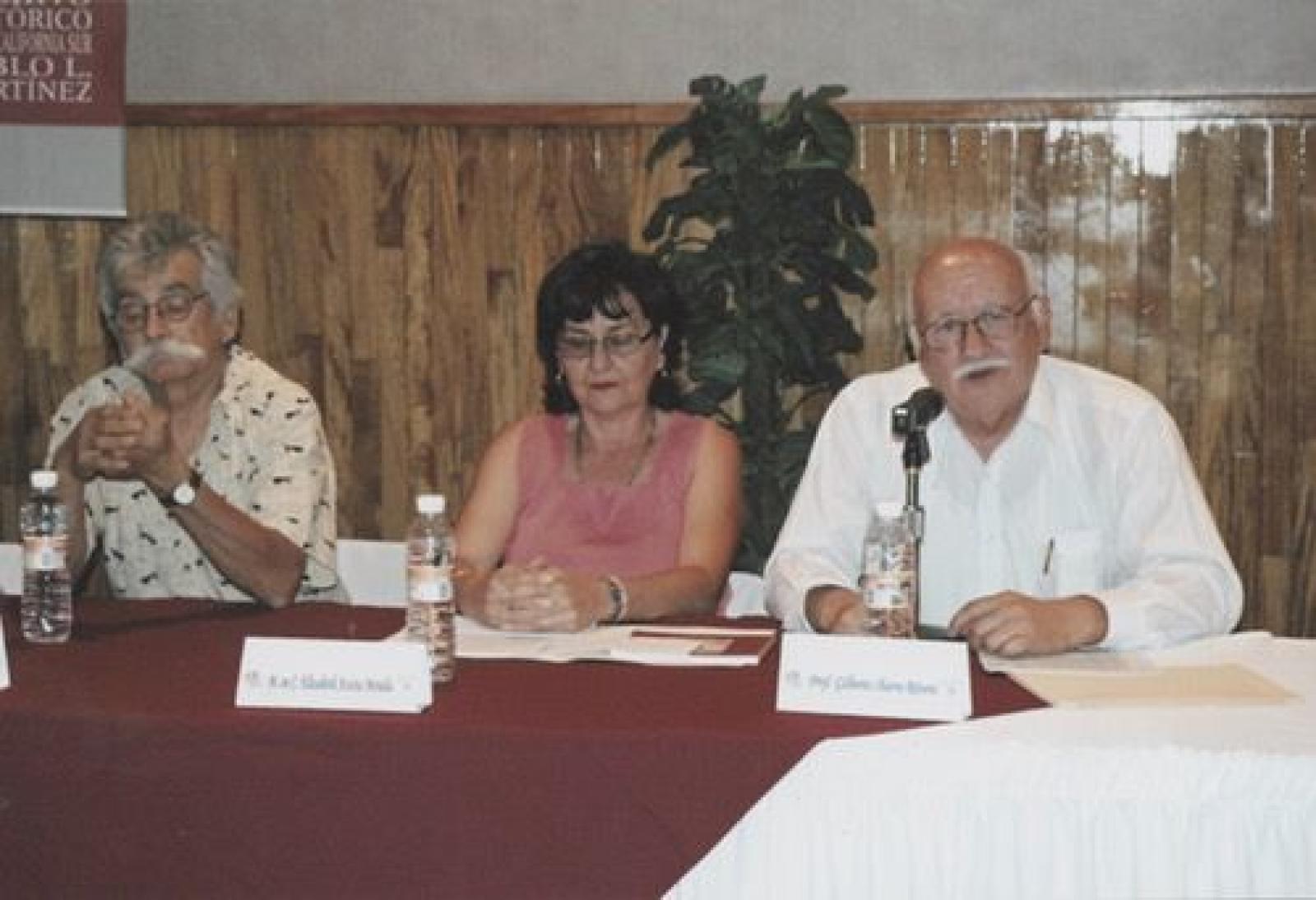 Gilberto Ibarra presenta el libro Paisajes y personajes en María Auxiliadora, Baja California Sur; en la mesa lo acompañan Aníbal Angulo y la autora, Elizabeth Acosta.
