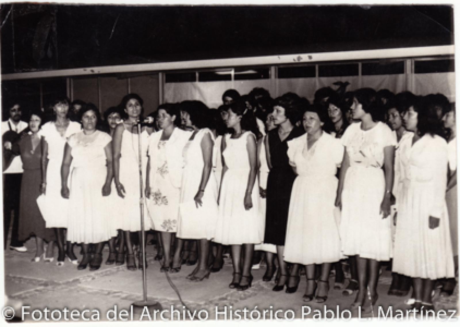 Grupo de mujeres, frente a micrófono.
