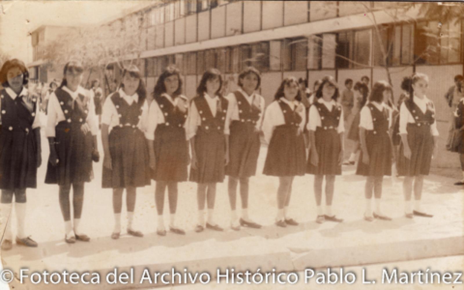 Grupo escolar en patio y frente a edificio