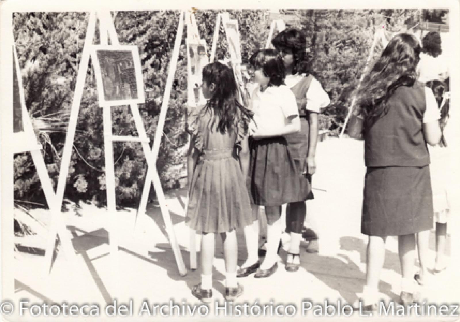 Grupo escolar que observa pinturas sobre caballetes