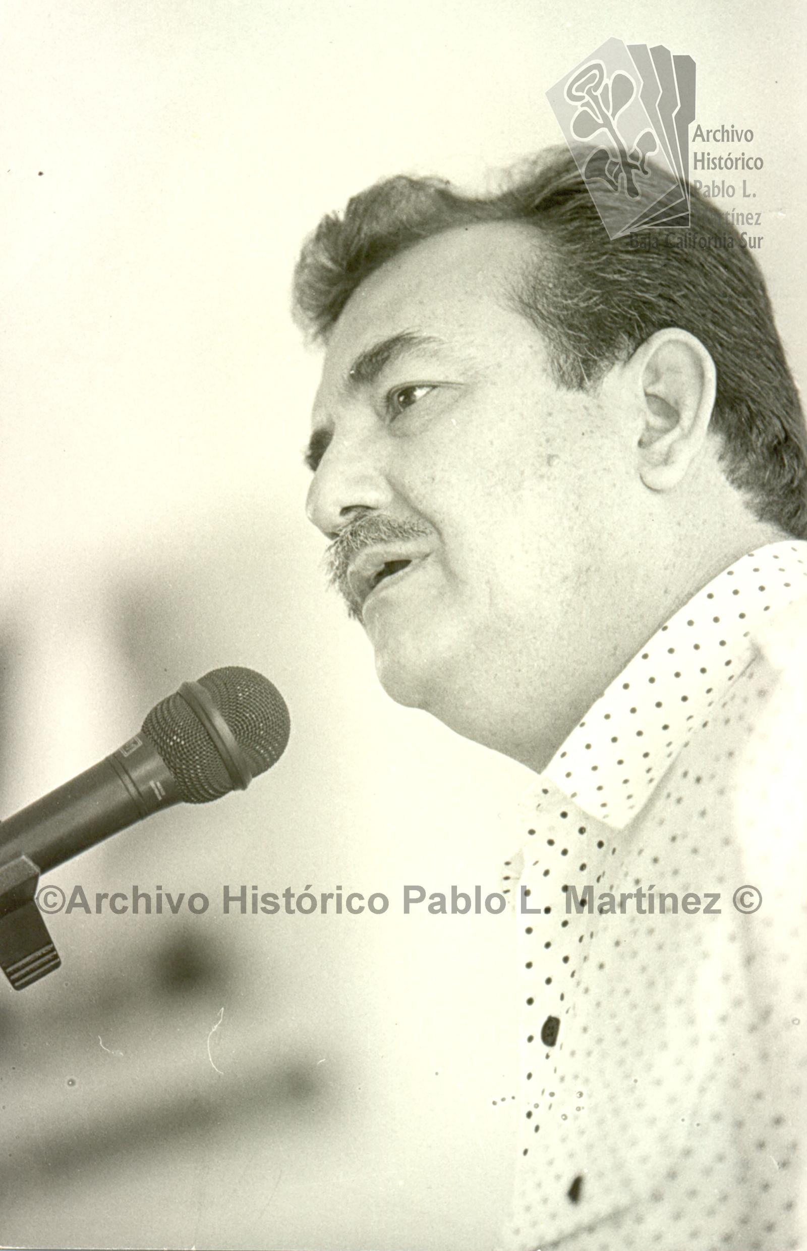Guillermo Mercado Romero frente a micrófono, retrato.