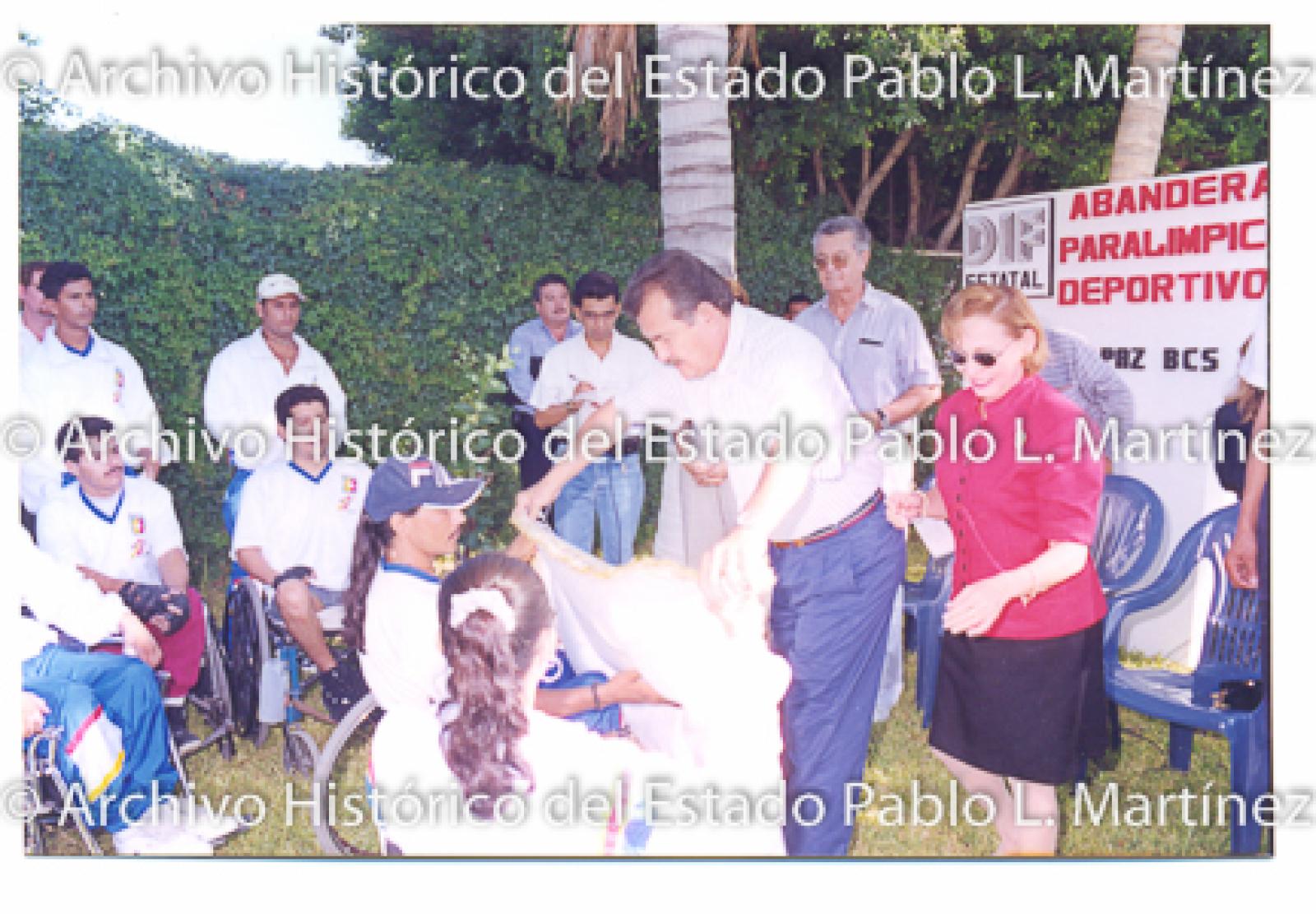 Guillermo Mercado Romero y Concepción Casas de Mercado en acto público con hombres y mujeres en sillas de ruedas.