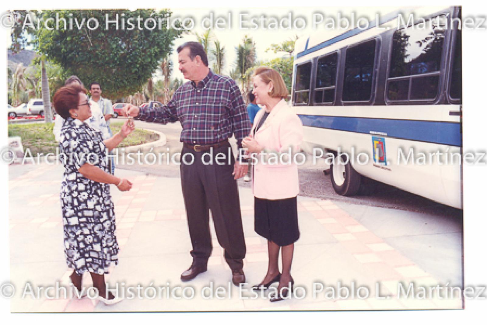 Guillermo Mercado Romero y Concepción Casas de Mercado entregan llaves de vehículo a mujer.