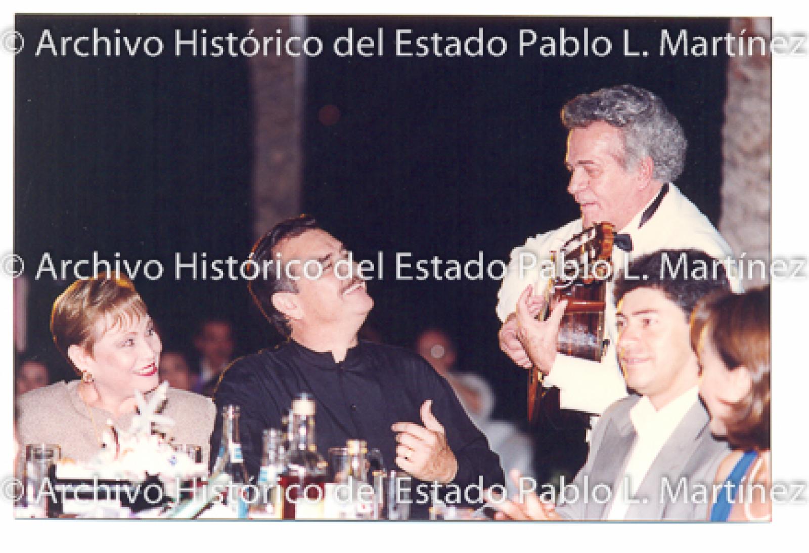 Guillermo Mercado Romero y Concepción Casas de Mercado escuchan a músico.