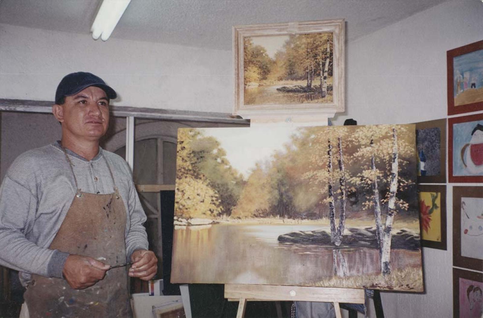 Héctor Vega junto a pintura.