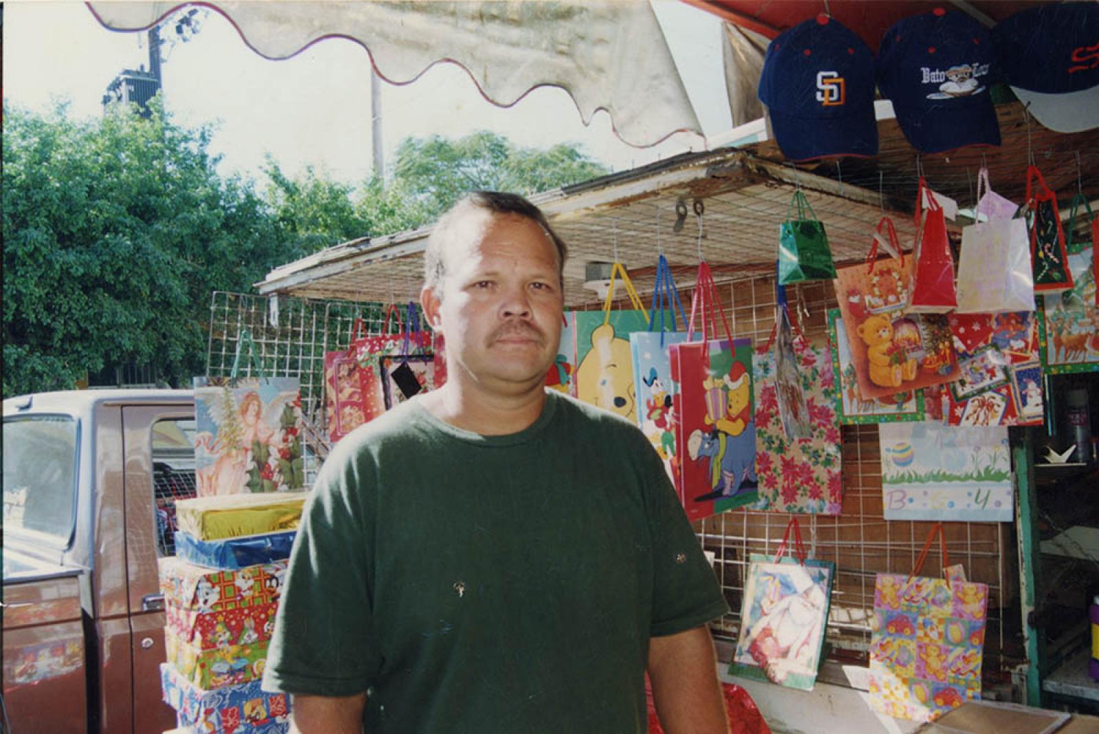Hombre en puesto de regalos, retrato.