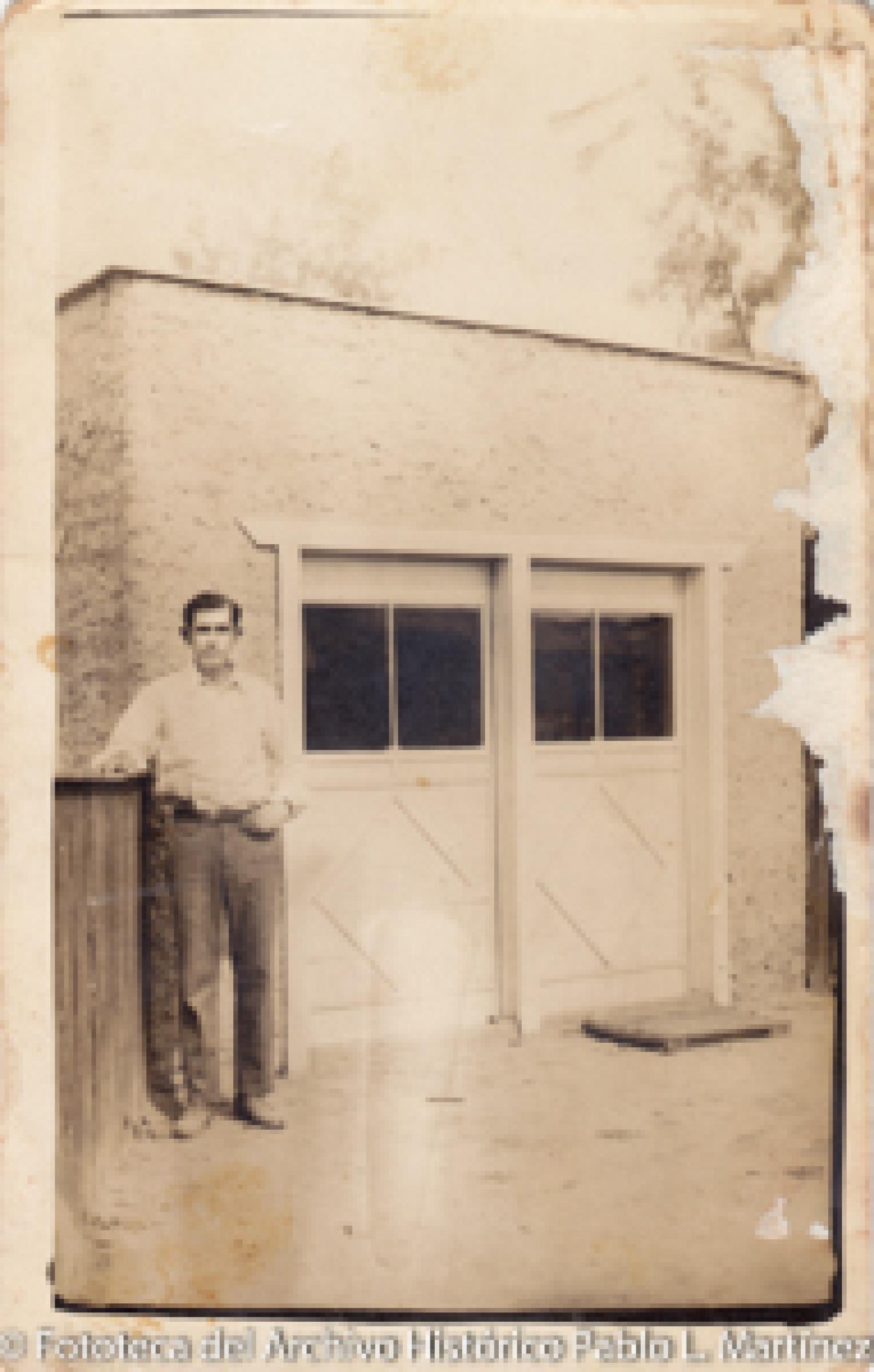 Hombre frente a casa con dos puertas.