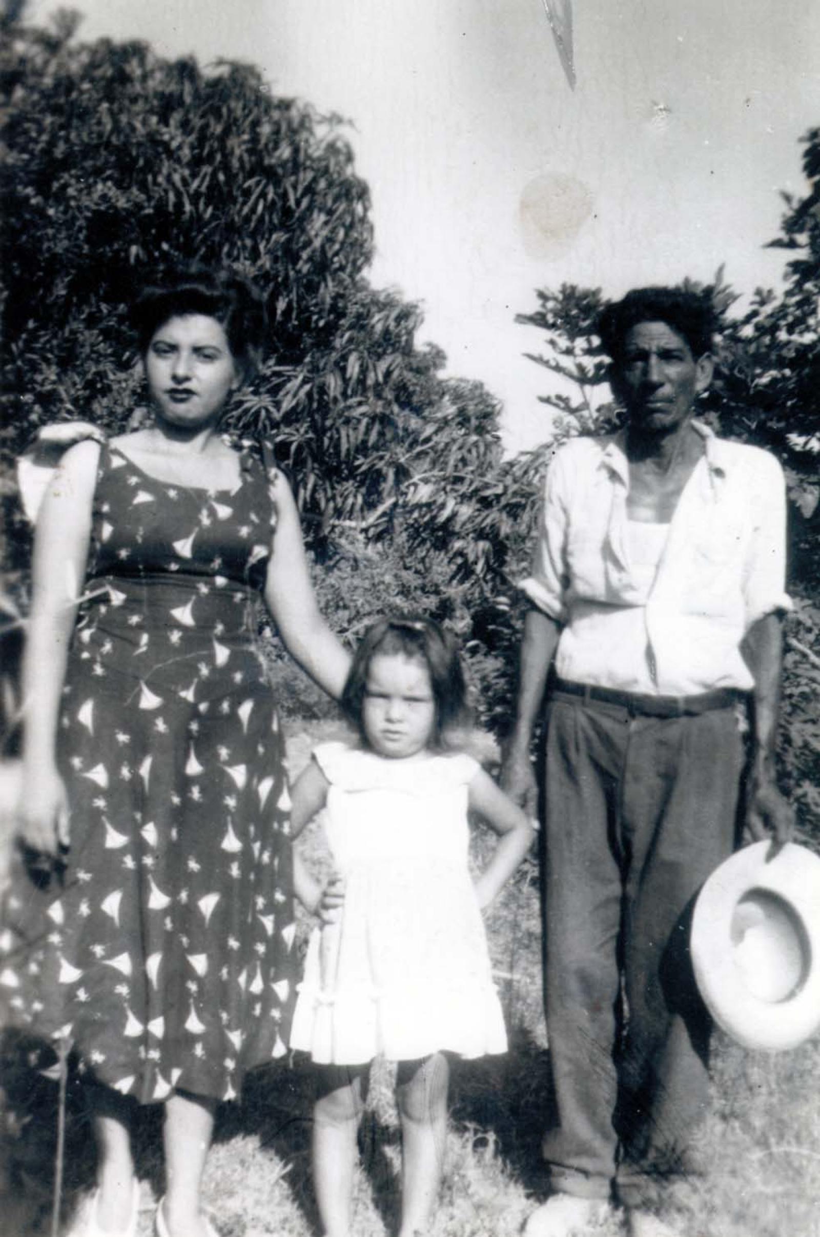 Hombre, mujer y niña; en el campo.