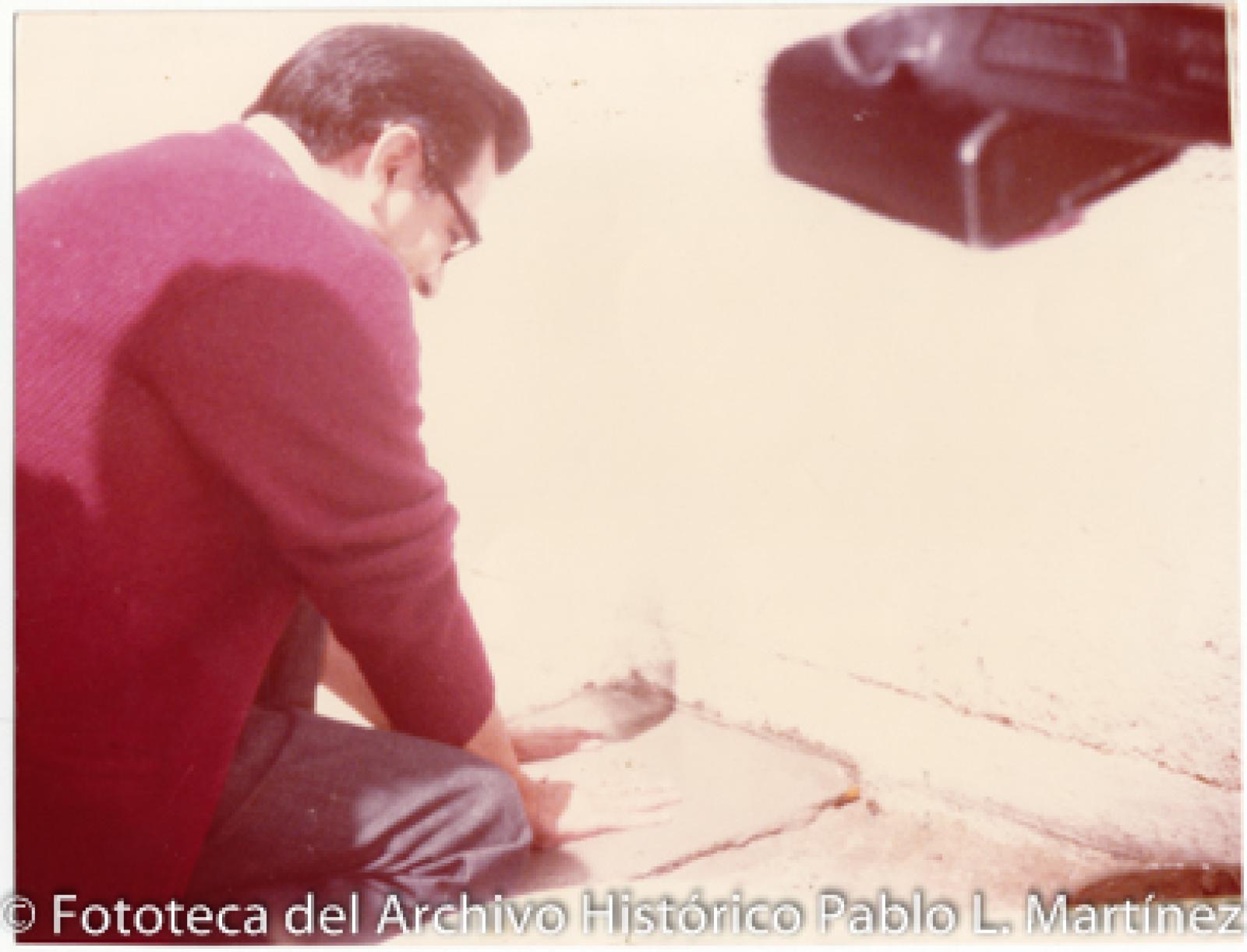 Hombre plasma sus manos en cemento fresco.