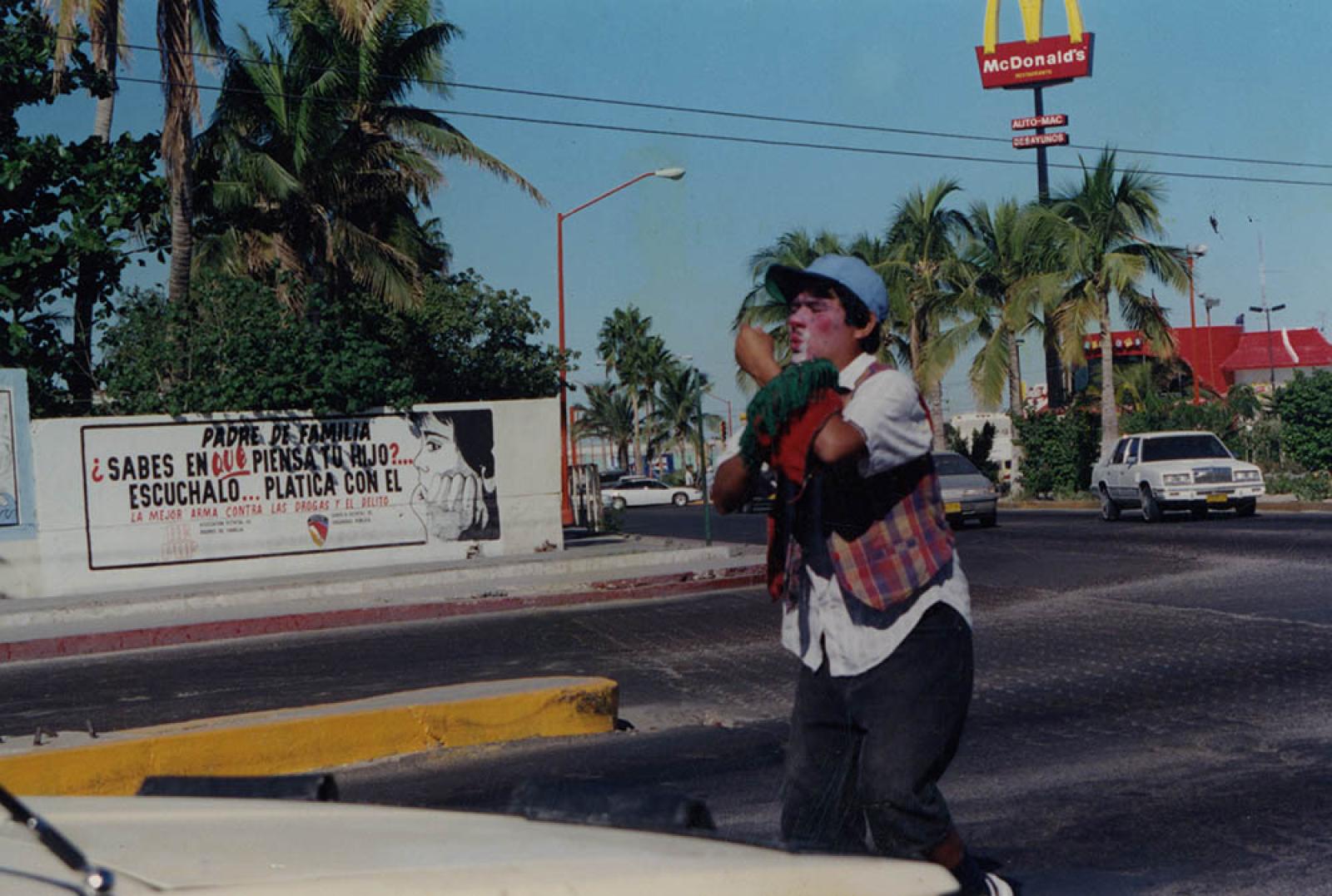 Hombre que viste como payaso da espectáculo en vía pública.