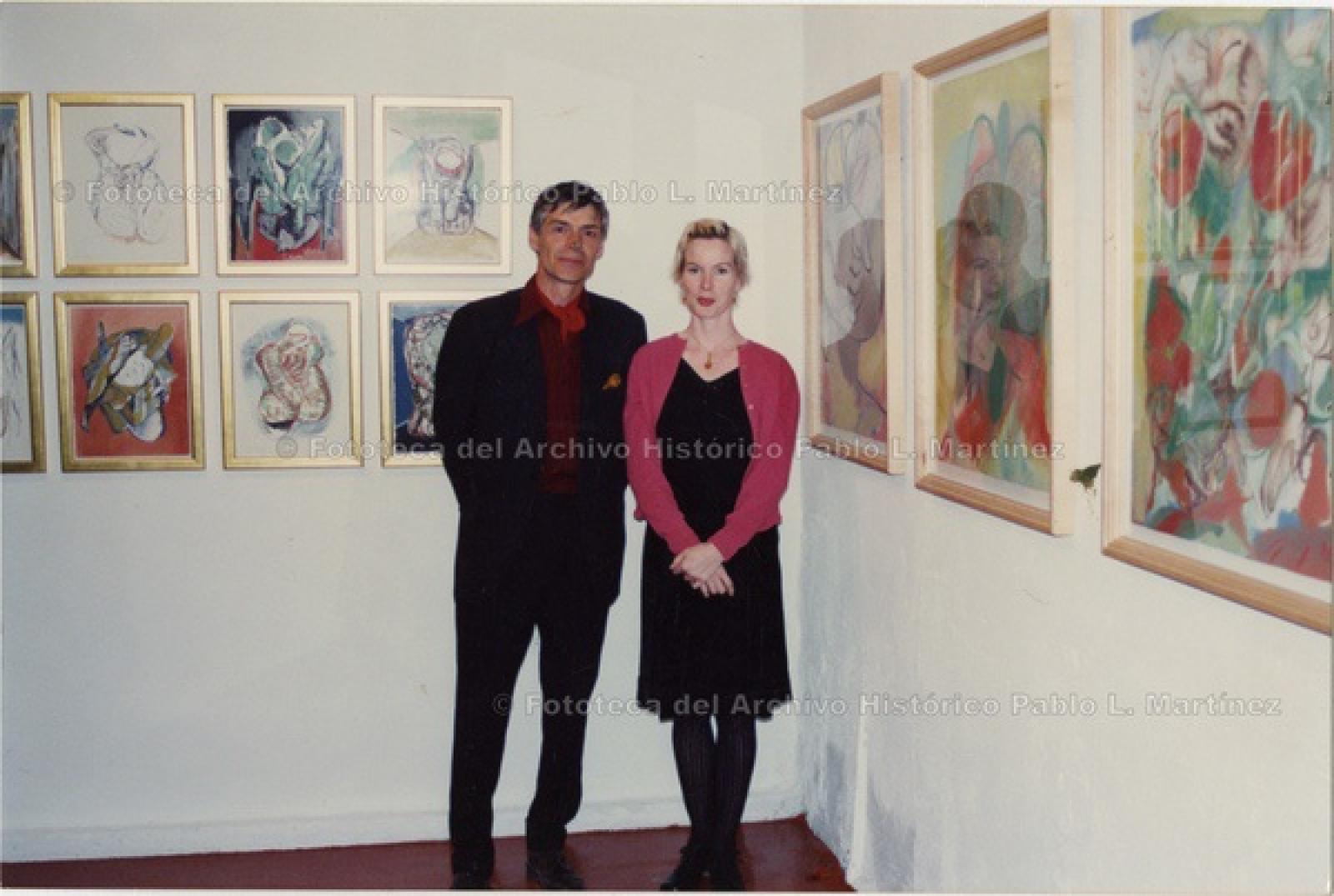 Hombre y mujer en exposición de pinturas.