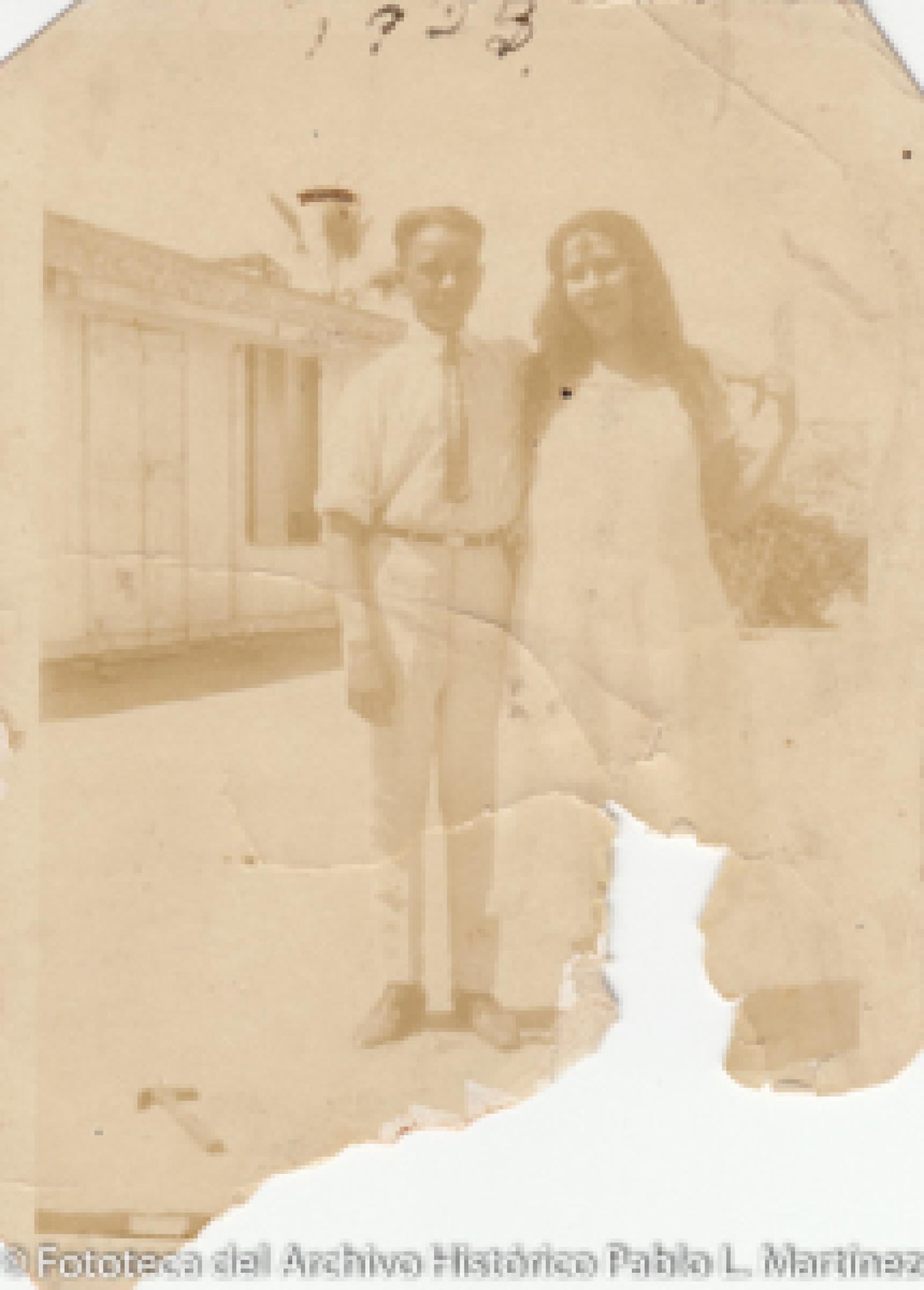 Hombre y mujer frente a casa de madera.