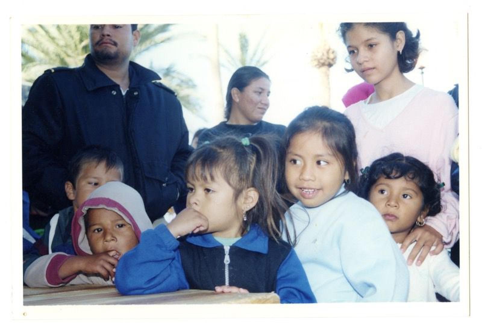 Hombre y mujer junto a grupo de niños.