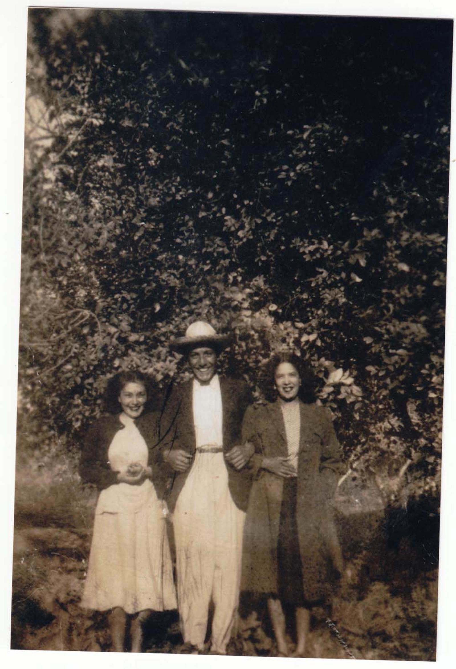 Hombre y mujeres, con árboles a su espalda.