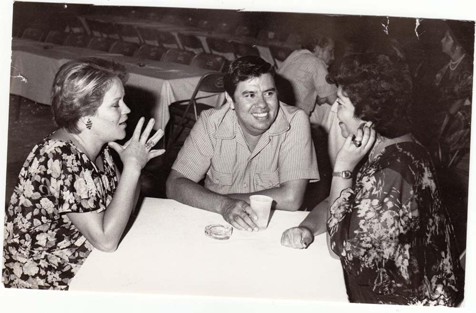 Hombre y mujeres en mesa.