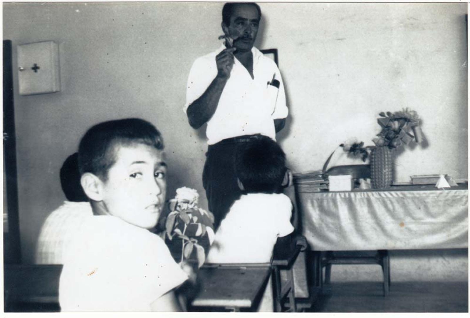 Hombre y niños en salón de clases.