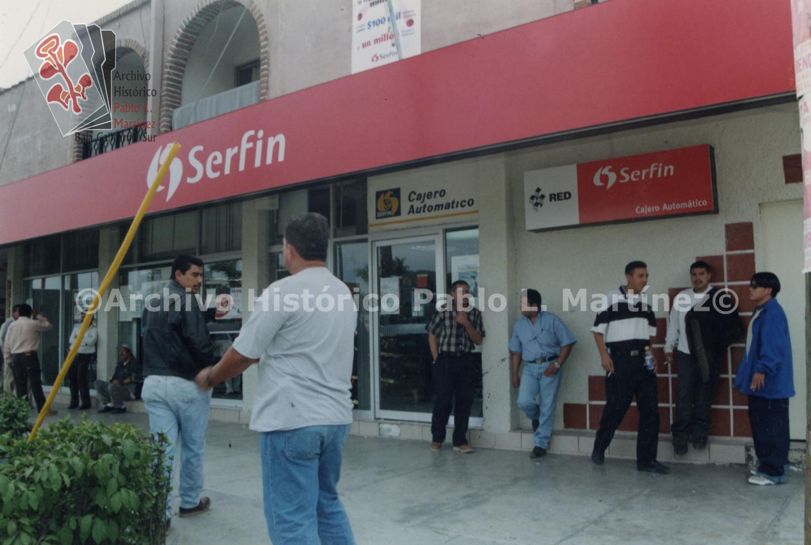 Hombres afuera del Banco Serfin en espera de cambiar cheques. Banco ubicado en la calle Antonio Rosales entre Isabel La Católica y Gral. Félix Ortega Aguilar.