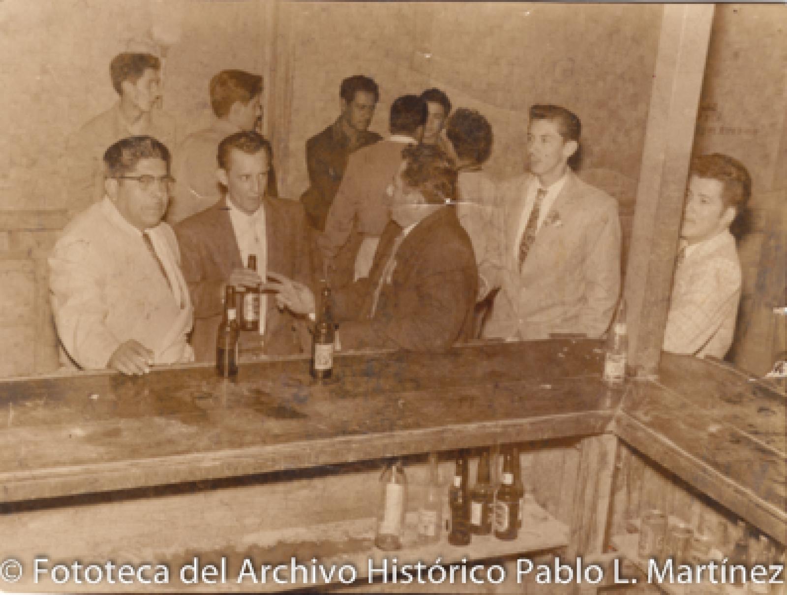 Hombres alrededor de barra.