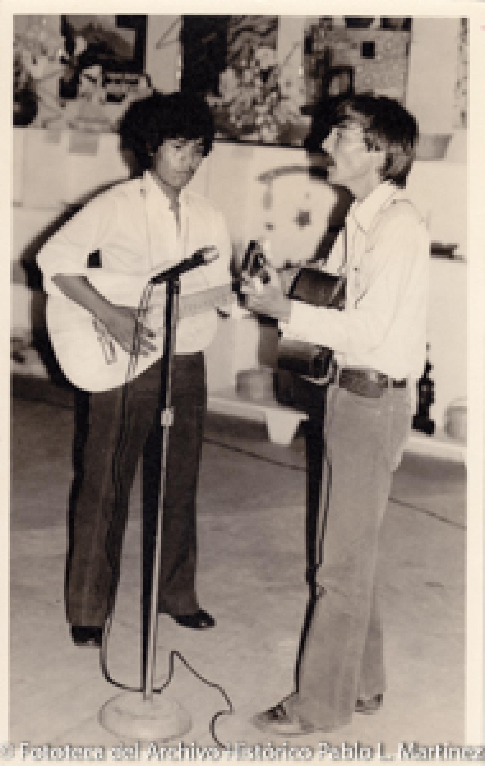 Hombres con guitarras frente a micrófono
