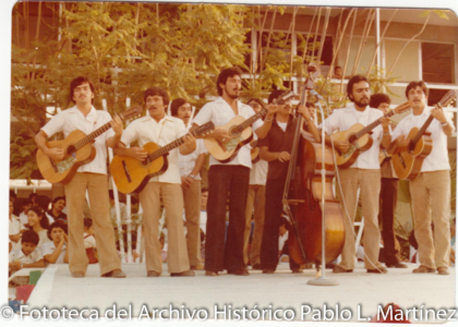 Hombres con instrumentos musicales frente a público