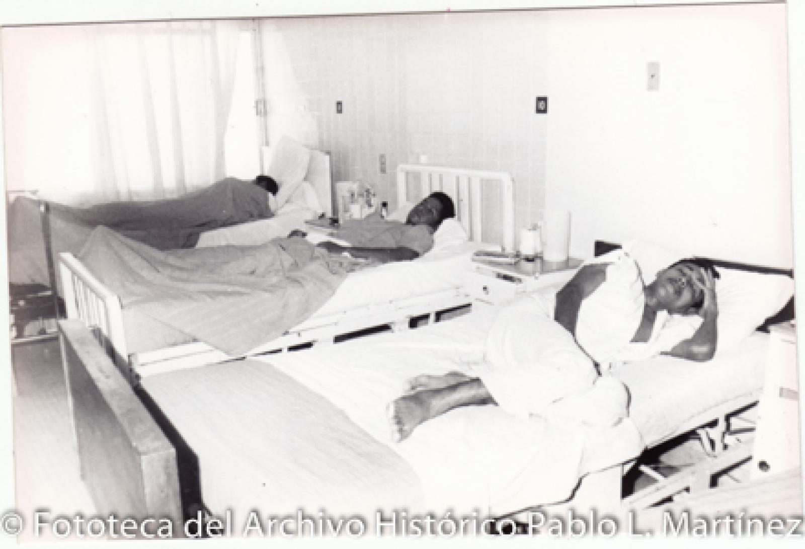 Hombres en camas de hospital.