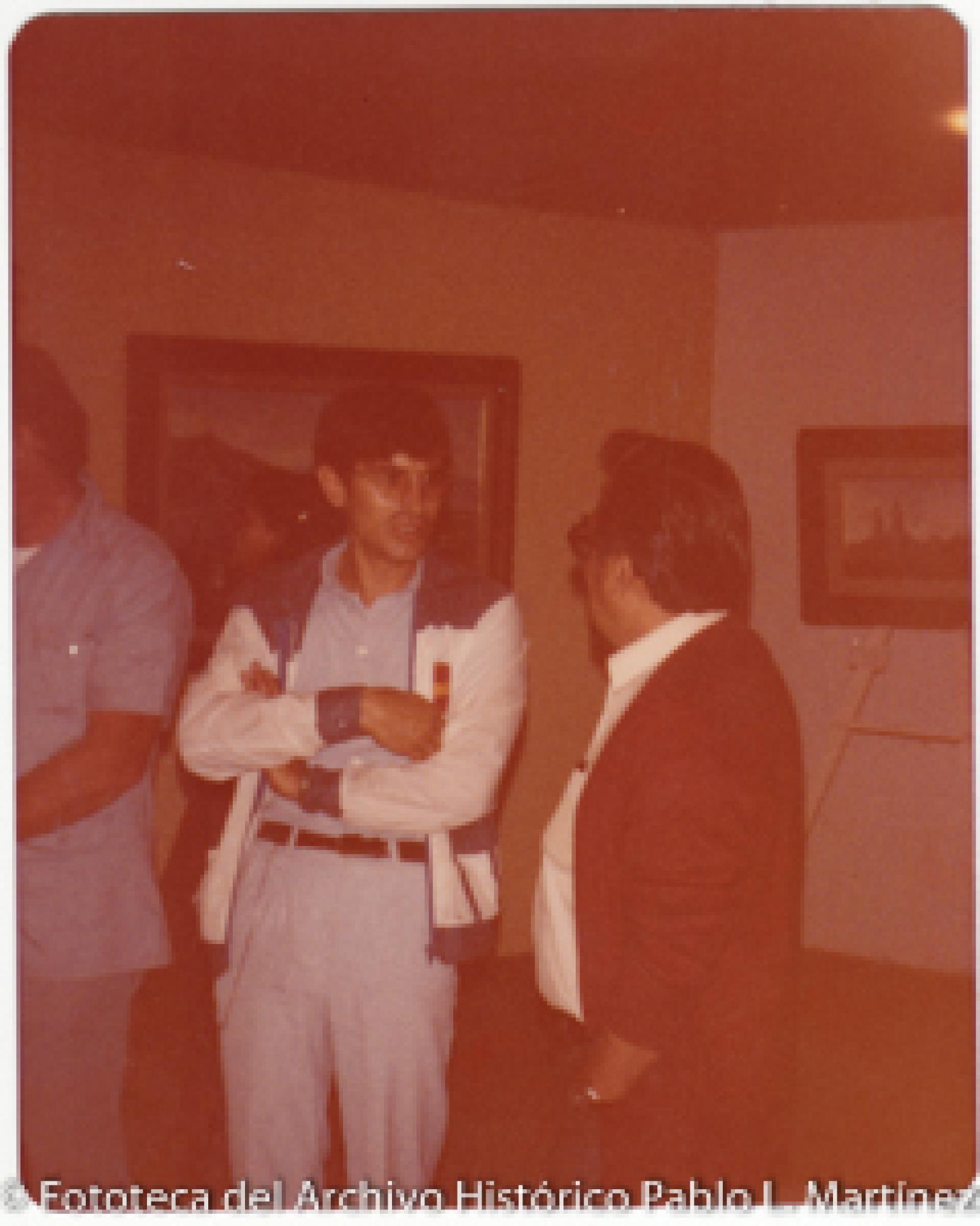 Hombres en exposición de pinturas.