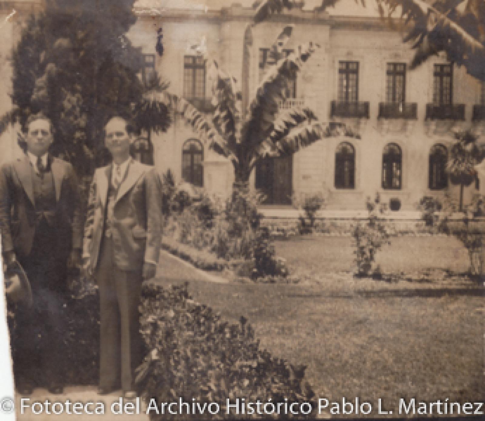 Hombres frente a edificio y Jardín.