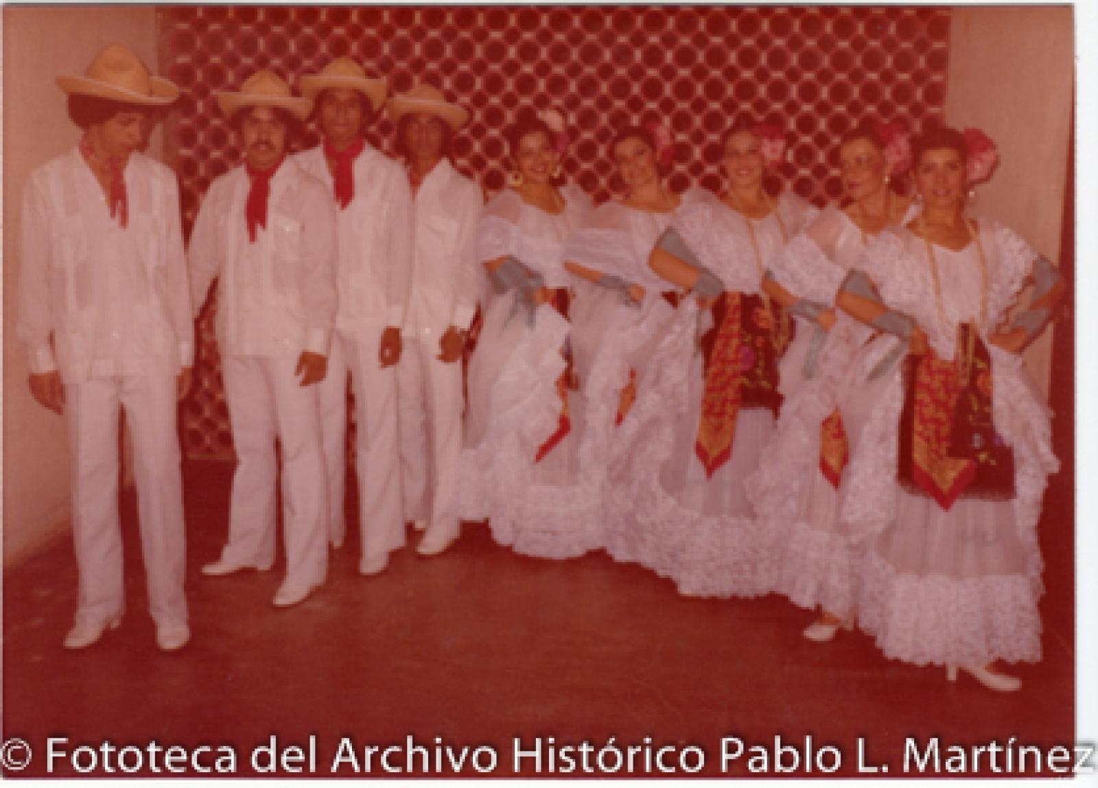 Hombres, mujer visten trajes típicos del sur de México.