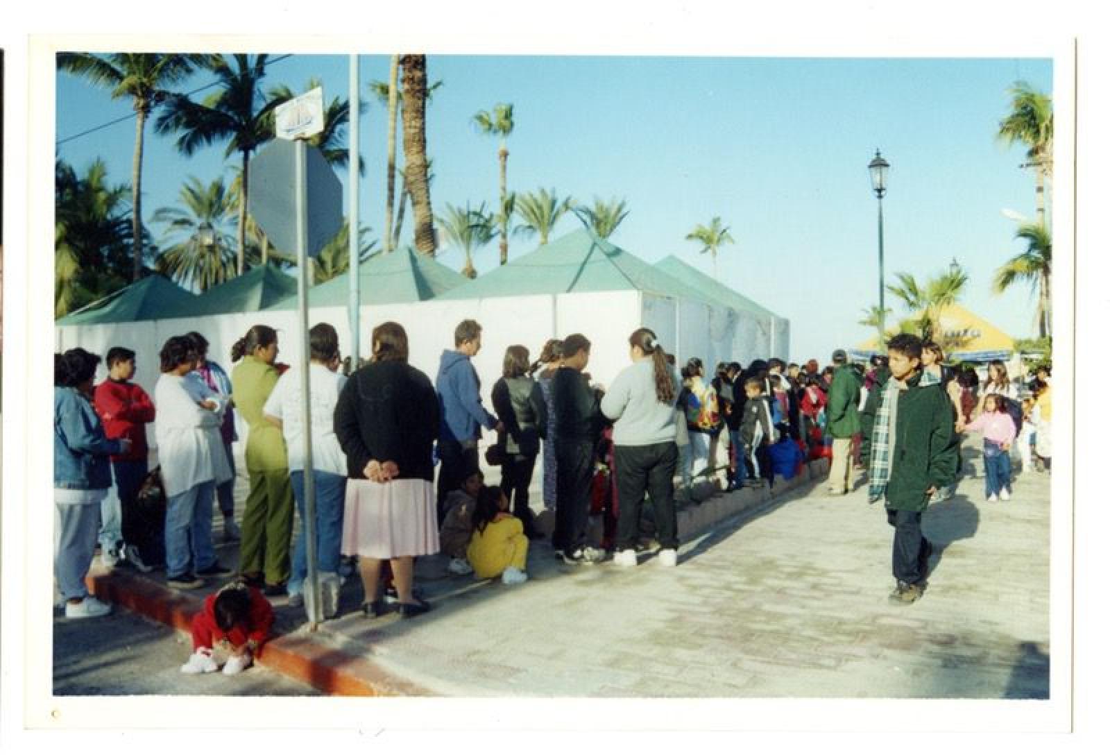 Hombres, mujeres y niños en explanada.