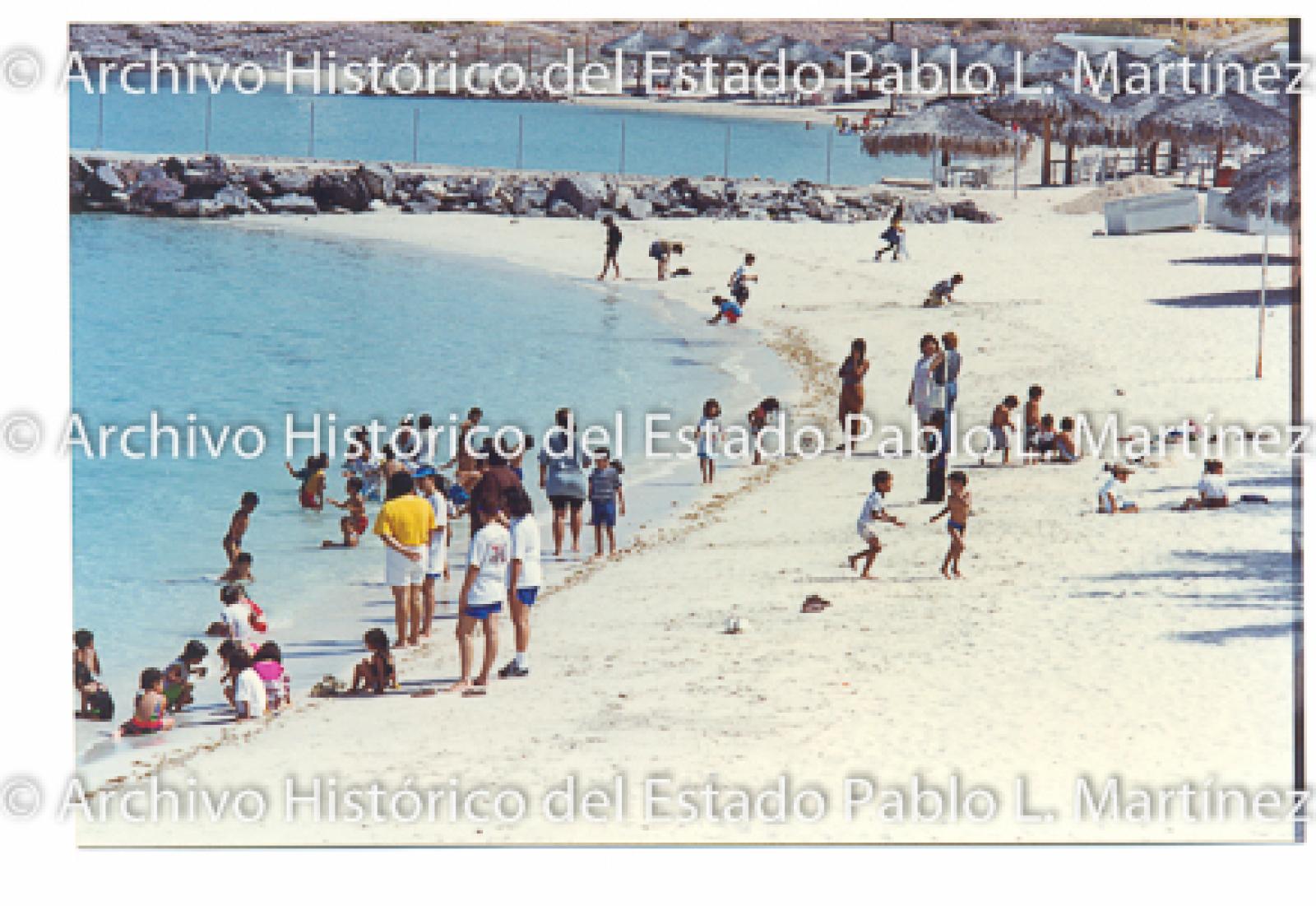 Hombres, mujeres y niños en la playa el caimancito.