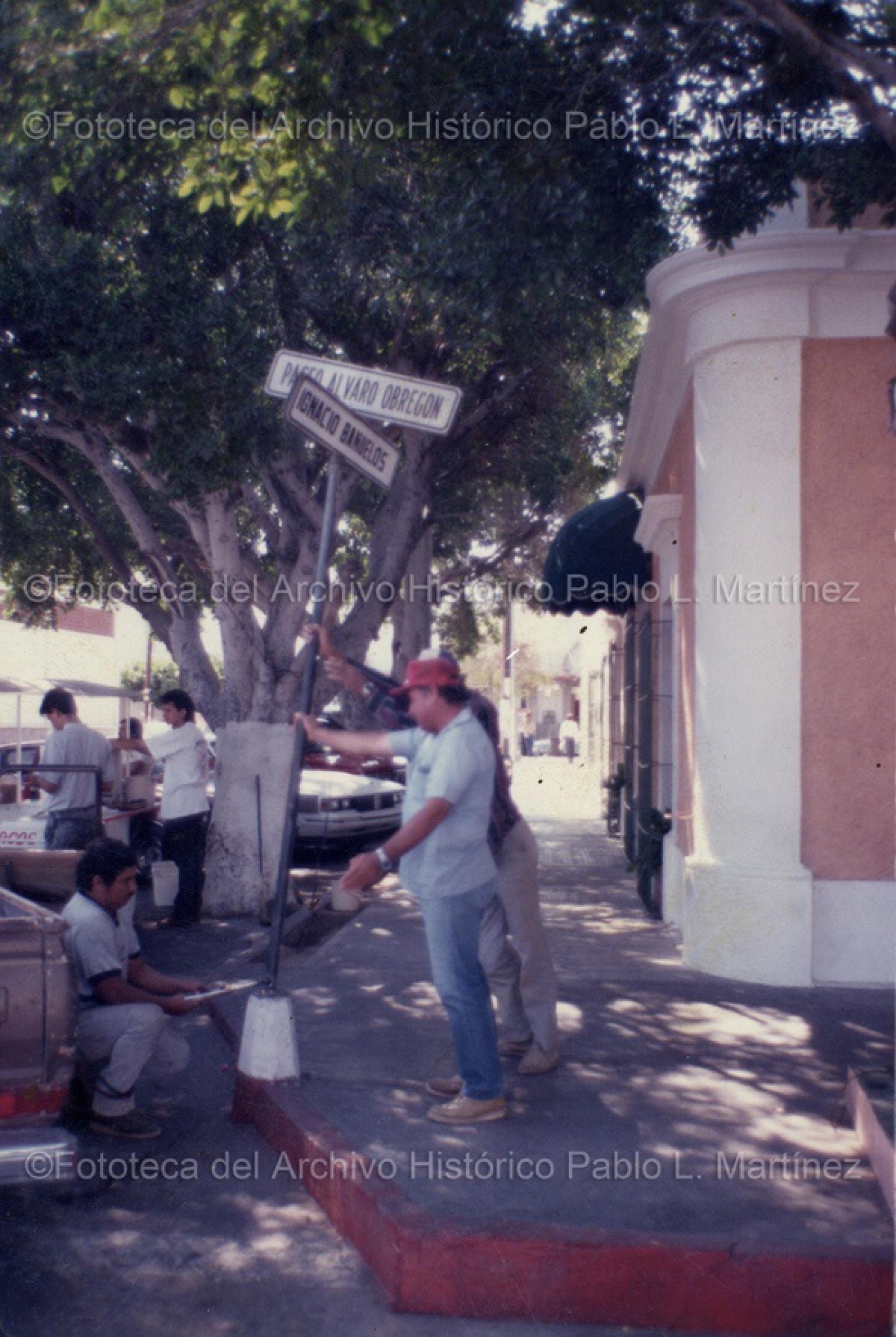 Hombres que arreglan nomenclatura en la zona del malecón de La Paz, B.C.S.